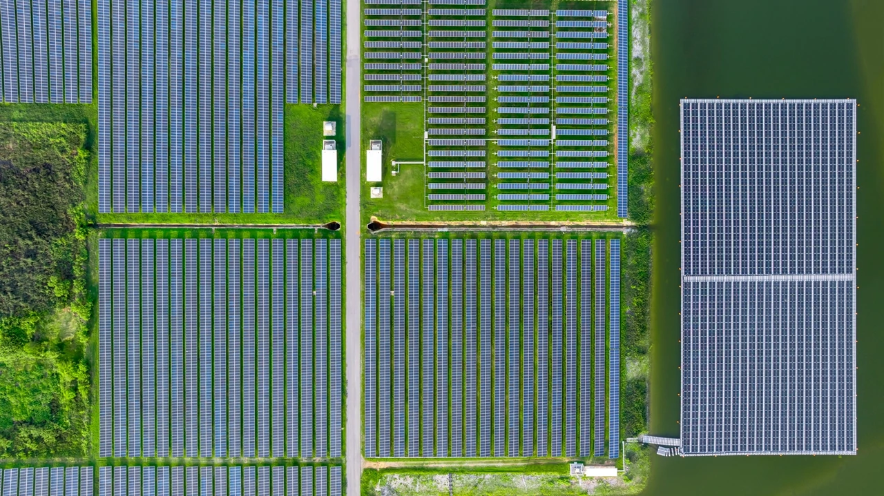 Aerial view of a hybrid solar farm combining ground-mounted and floating photovoltaic systems, demonstrating dual land and water use for renewable energy generation.