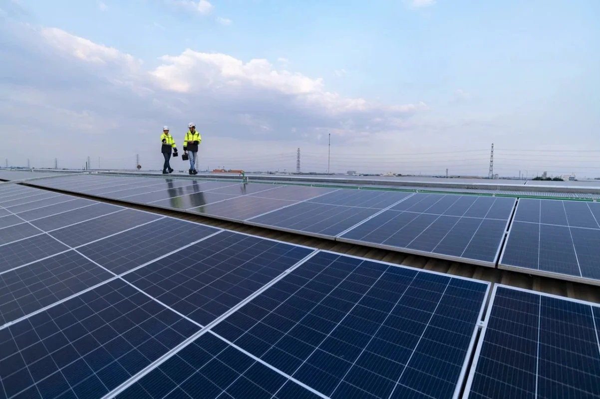 Dwóch techników sprawdza instalację fotowoltaiczną 100 kW w celu maksymalizacji zwrotu z inwestycji.