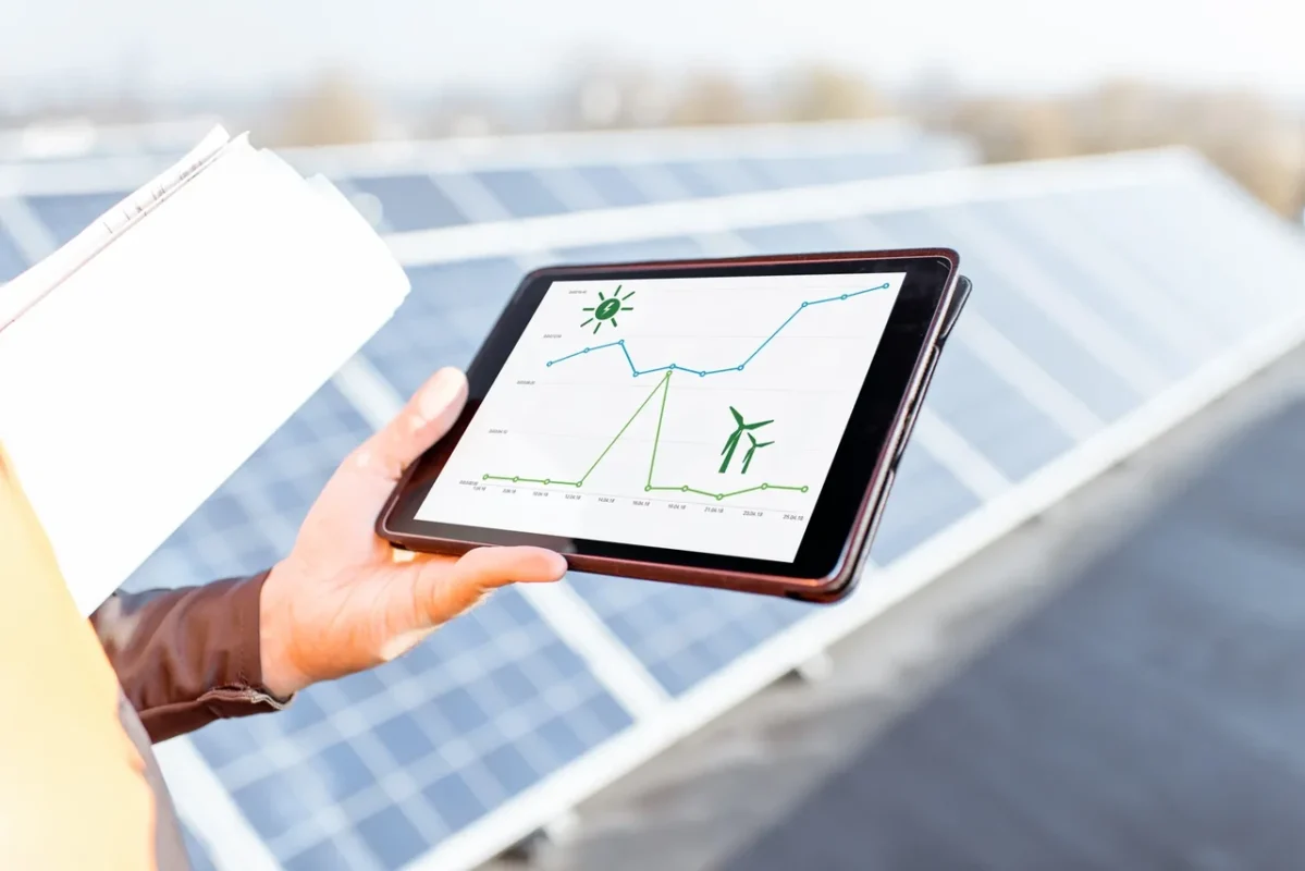 Monitorowanie wydajności farmy PV za pomocą tabletu z wykresami energetycznymi w ramach serwisu.