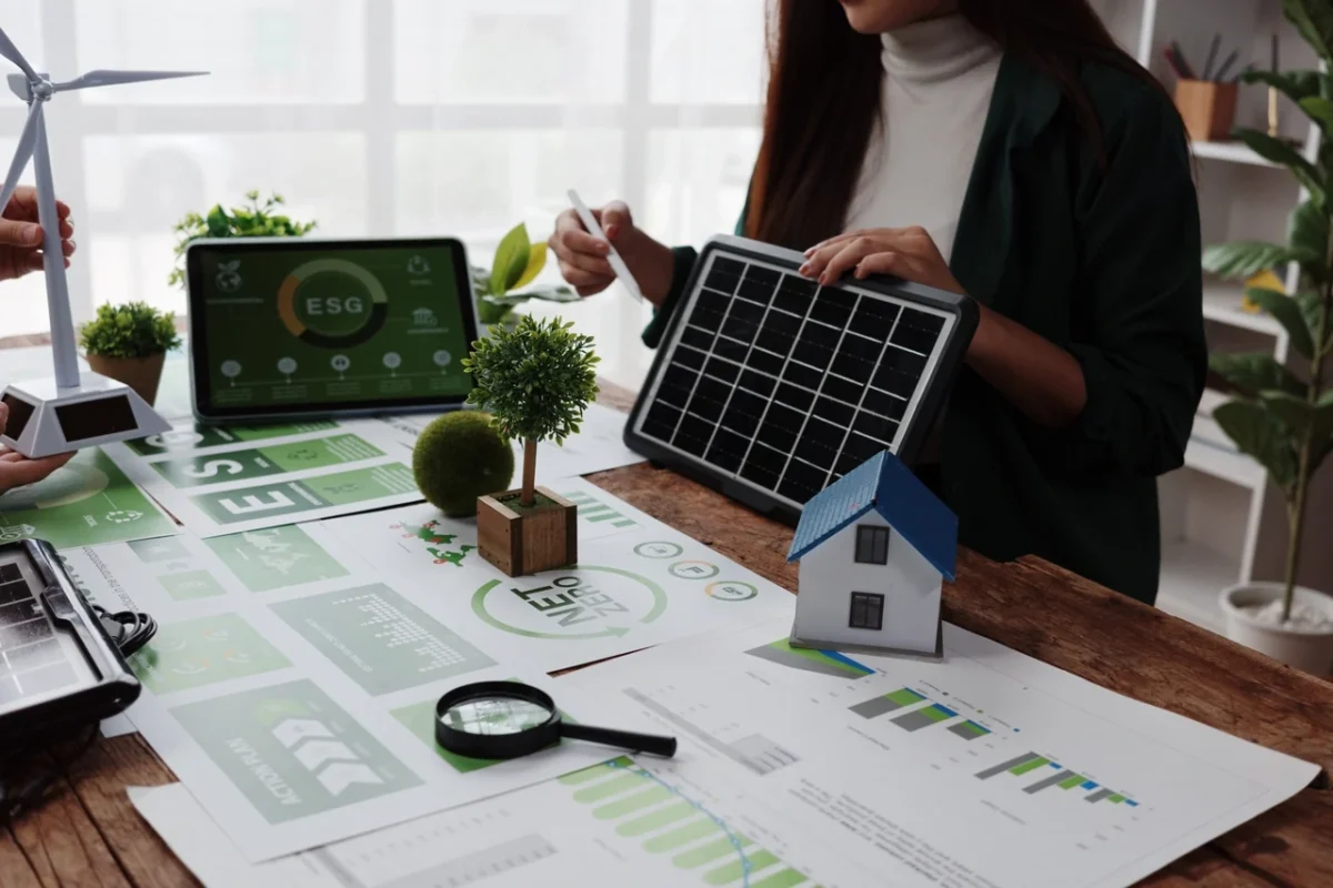 Business meeting table with ESG reports, solar panel models, and data charts, used for planning sustainable solar energy investments and corporate sustainability strategies.
