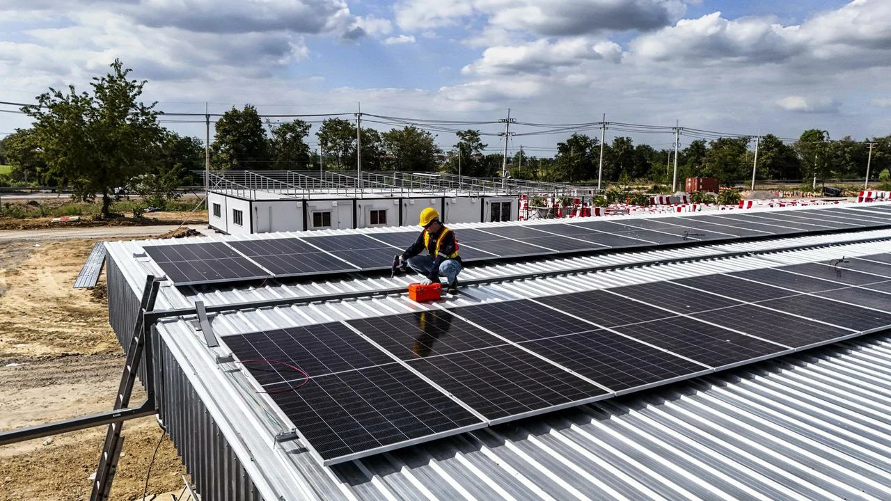 Instalator sprawdza połączenia w instalacji 100 kW, analizując zwrot z inwestycji w fotowoltaikę.