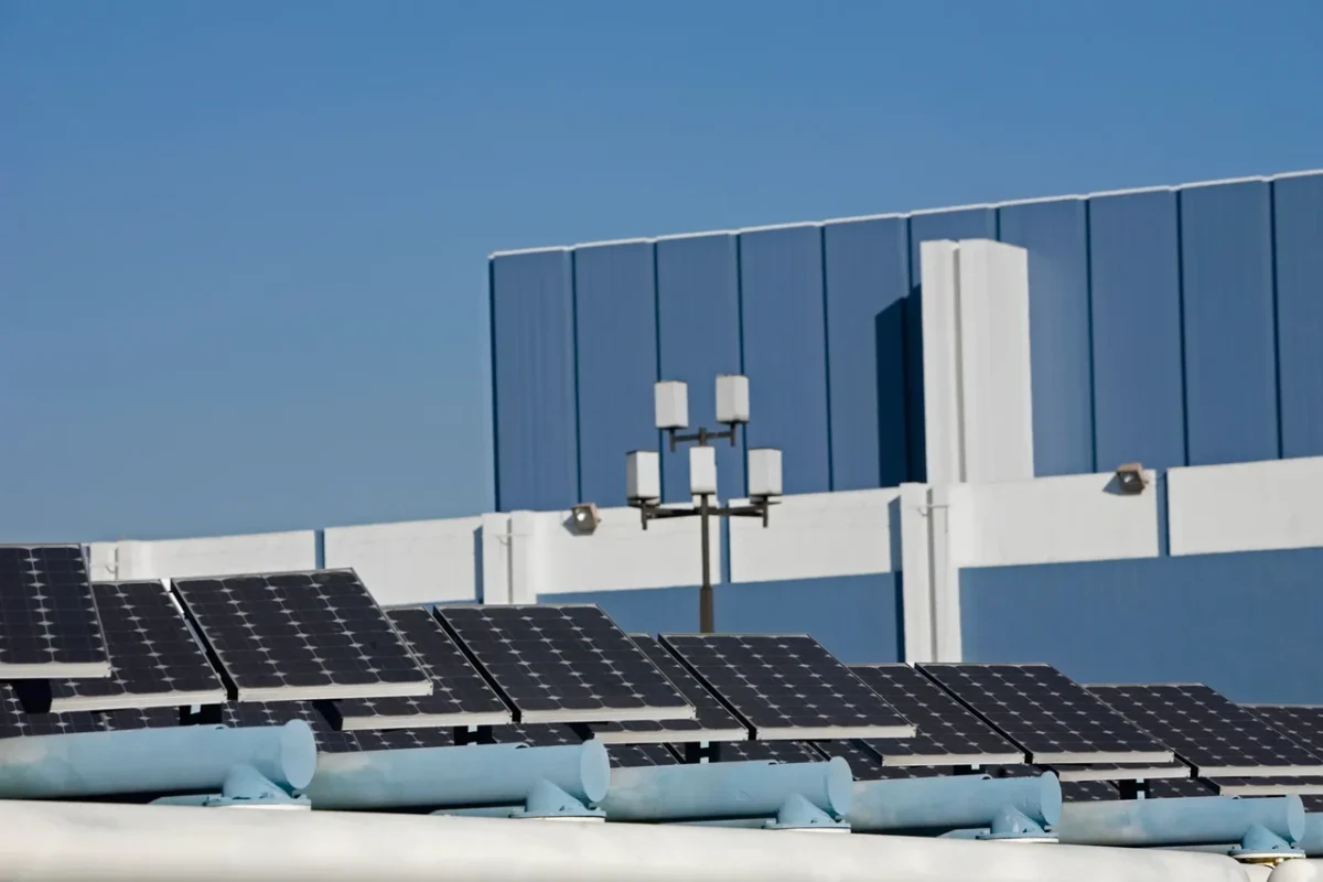 Panele słoneczne zamontowane na dachu budynku komercyjnego, wytwarzające czystą energię elektryczną w celu ograniczenia kosztów operacyjnych i wsparcia integracji rozproszonej energii w wirtualne elektrownie (VPP).