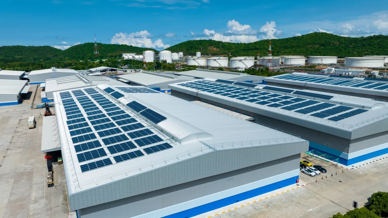Rozległa instalacja fotowoltaiczna na dachu hali przemysłowej wykorzystywana do zaspokojenia dużego zapotrzebowania energetycznego zakładu produkcyjnego.