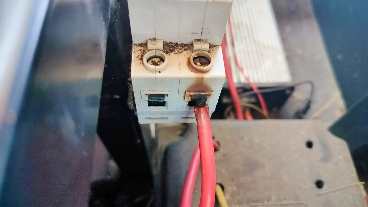 Uszkodzone złącze elektryczne z oparzeniami, ilustrując ryzyko przegrzania jako przyczyny deratingu inwertera.