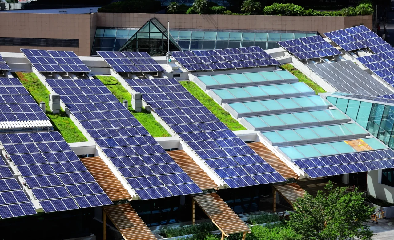 Fotowoltaiczne panele montowane na dachu budynku użyteczności publicznej do produkcji zielonej energii elektrycznej i obniżenia kosztów eksploatacyjnych.