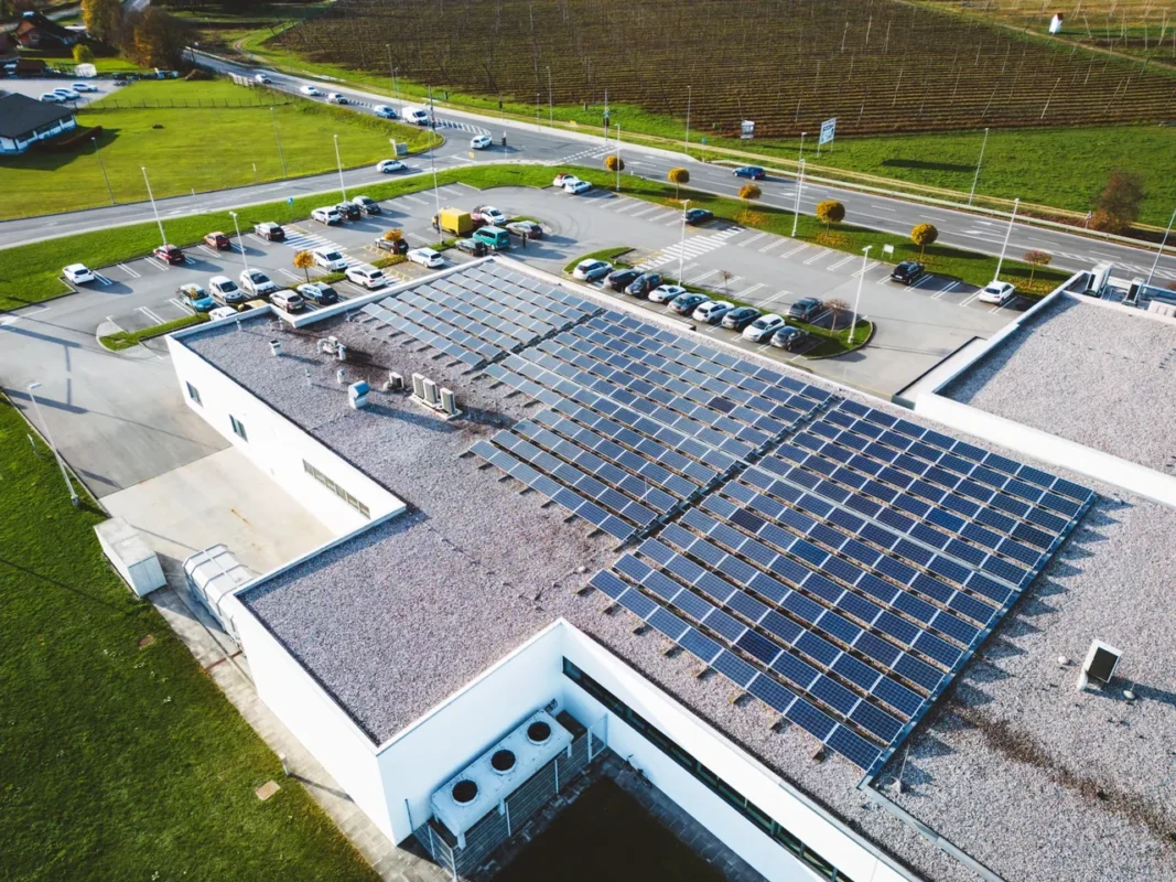 Dachowa instalacja fotowoltaiczna na budynku komercyjnym, pokazując kontekst zastosowania ochronników przepięć DC w systemach PV.