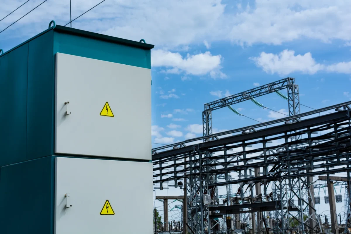 Szafa rozdzielcza elektryczna na tle infrastruktury stacji transformatorowej.
