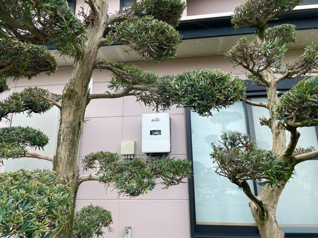 Falownik marki Afore instalowany na elewacji domu mieszkalnego jako element hybrydowej instalacji fotowoltaicznej działającej w trybach on-grid oraz off-grid.
